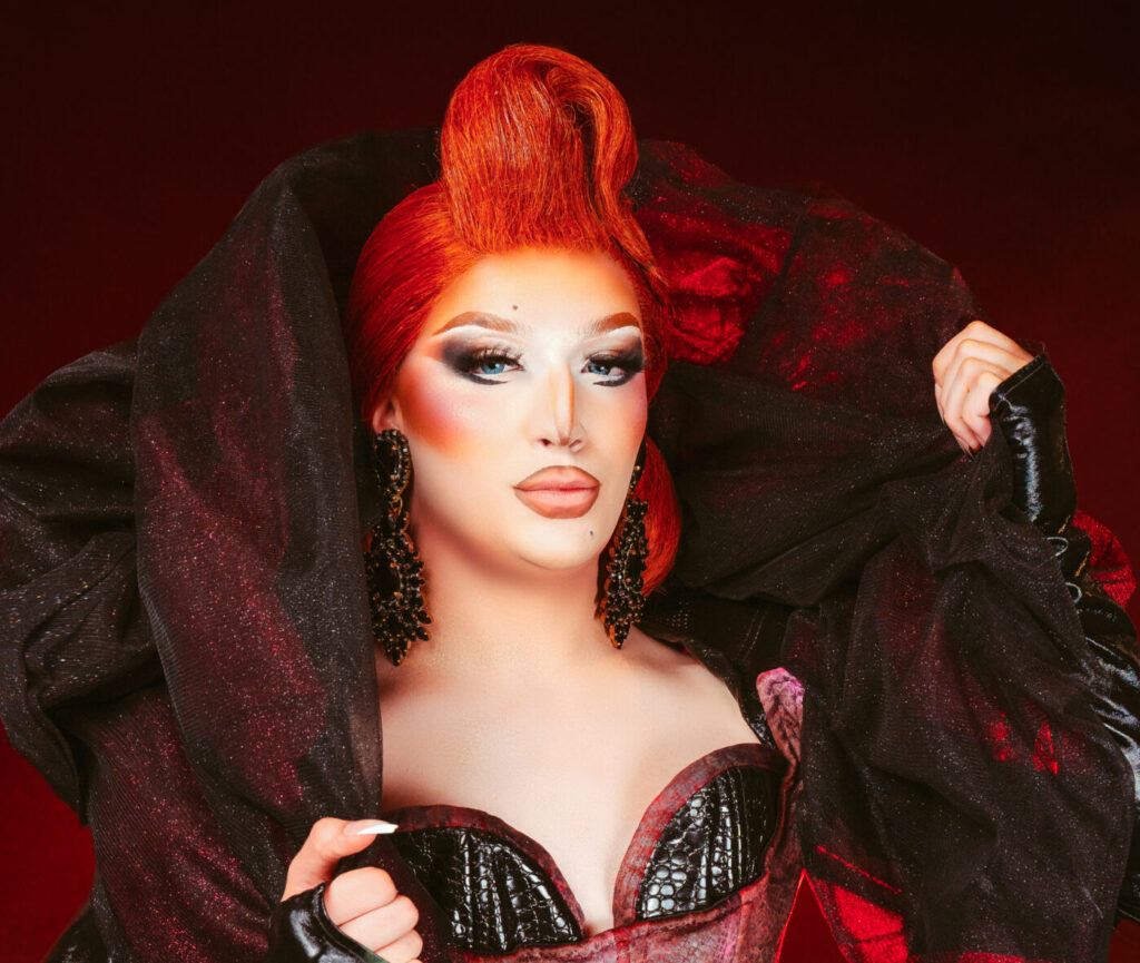 Photo of a drag queen with red hair on a black background